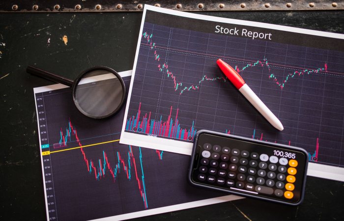 Stock report with charts, calculator, and magnifying glass for financial analysis.
