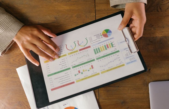 Top view of hands holding a financial report with colorful graphs and charts, ideal for business presentations.