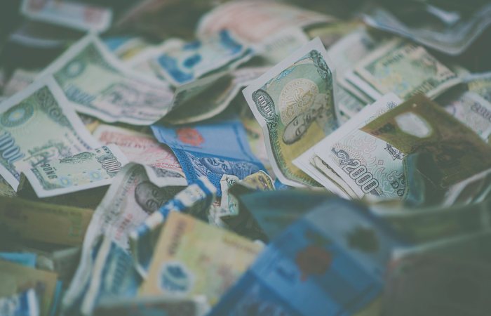 A close-up view of diverse international currency banknotes in soft focus, conveying wealth and finance themes.