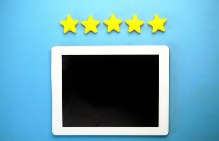Tablet with five yellow stars on a blue background, ideal for rating concepts.